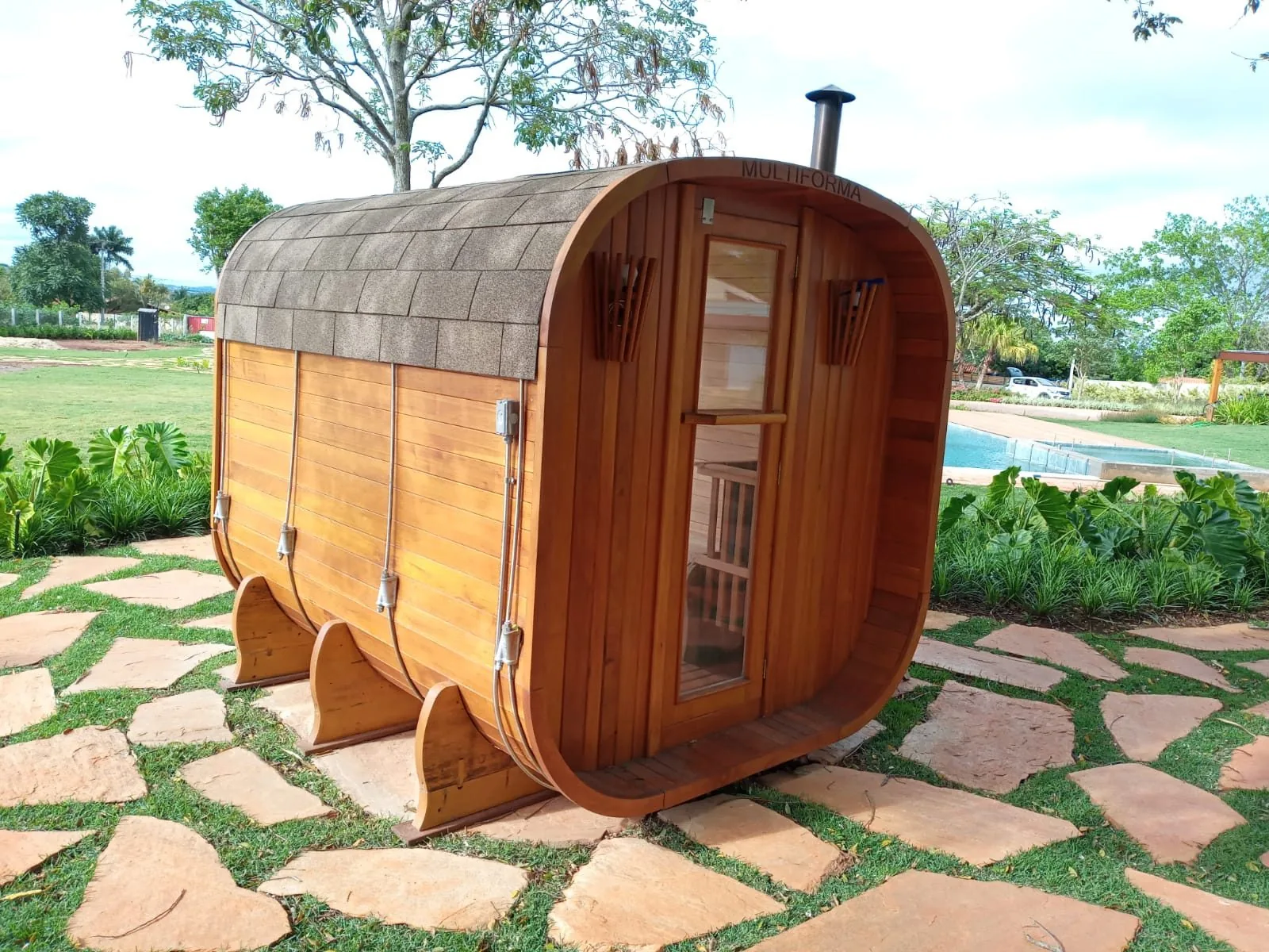 Sauna externa em madeira maciça em formato arredondado