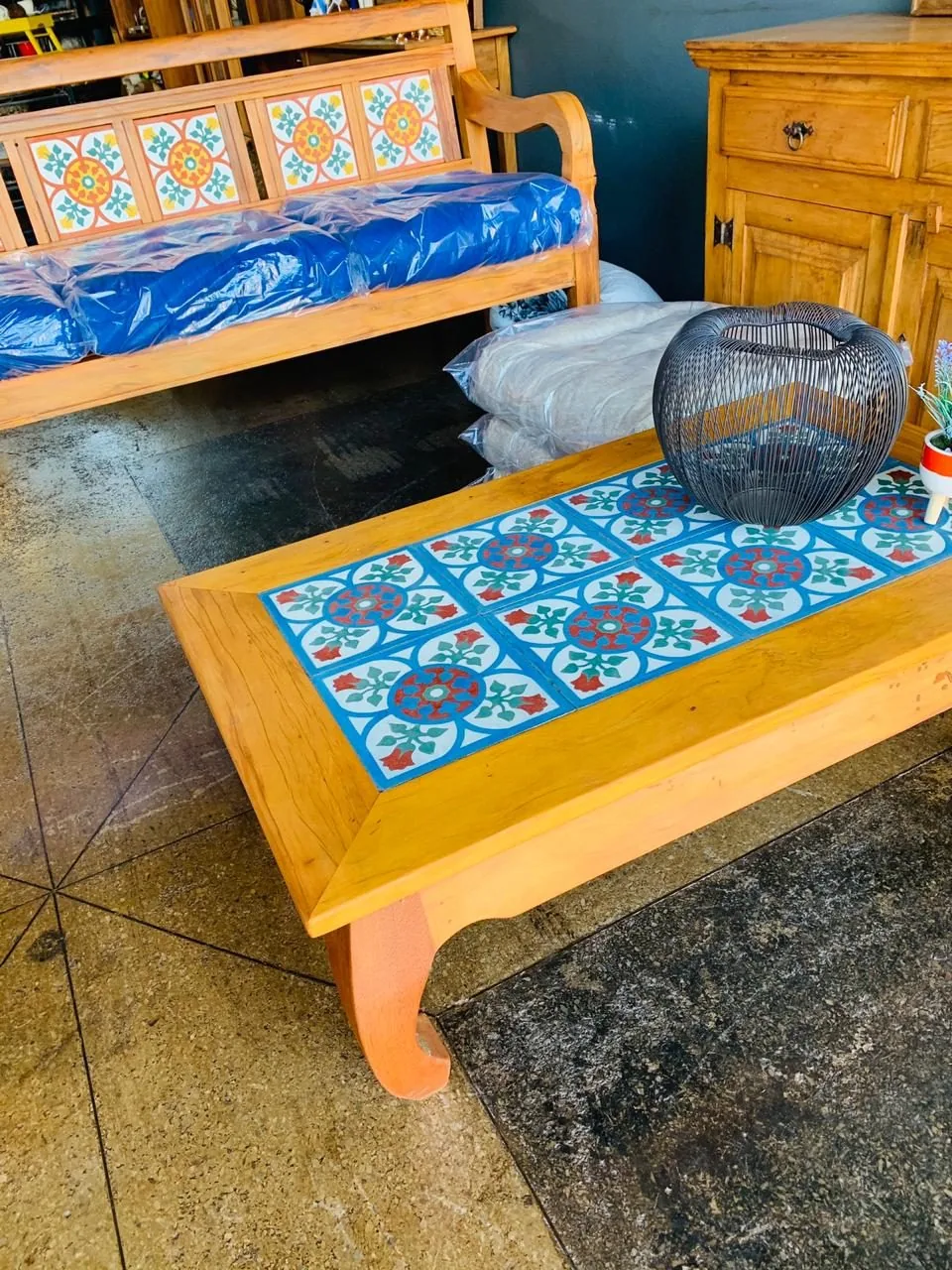 Mesa de centro com tampo de azulejos coloridos sobre estrutura de madeira